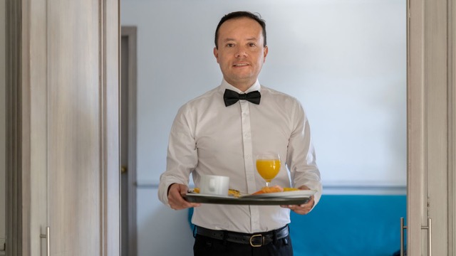 Un mesero que lleva comida a una habitación de motel.