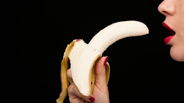 Mujer jugando un juego erótico con un plátano