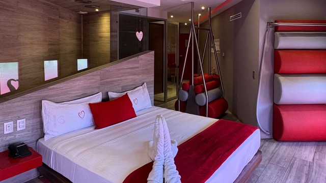  Habitación de motel con tonos rojos, muy cómoda.