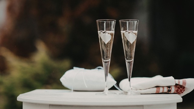 Dos copas de vino blanco espumoso, en una mesa de hotel.