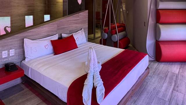 Una habitación de motel con motivos rojos.