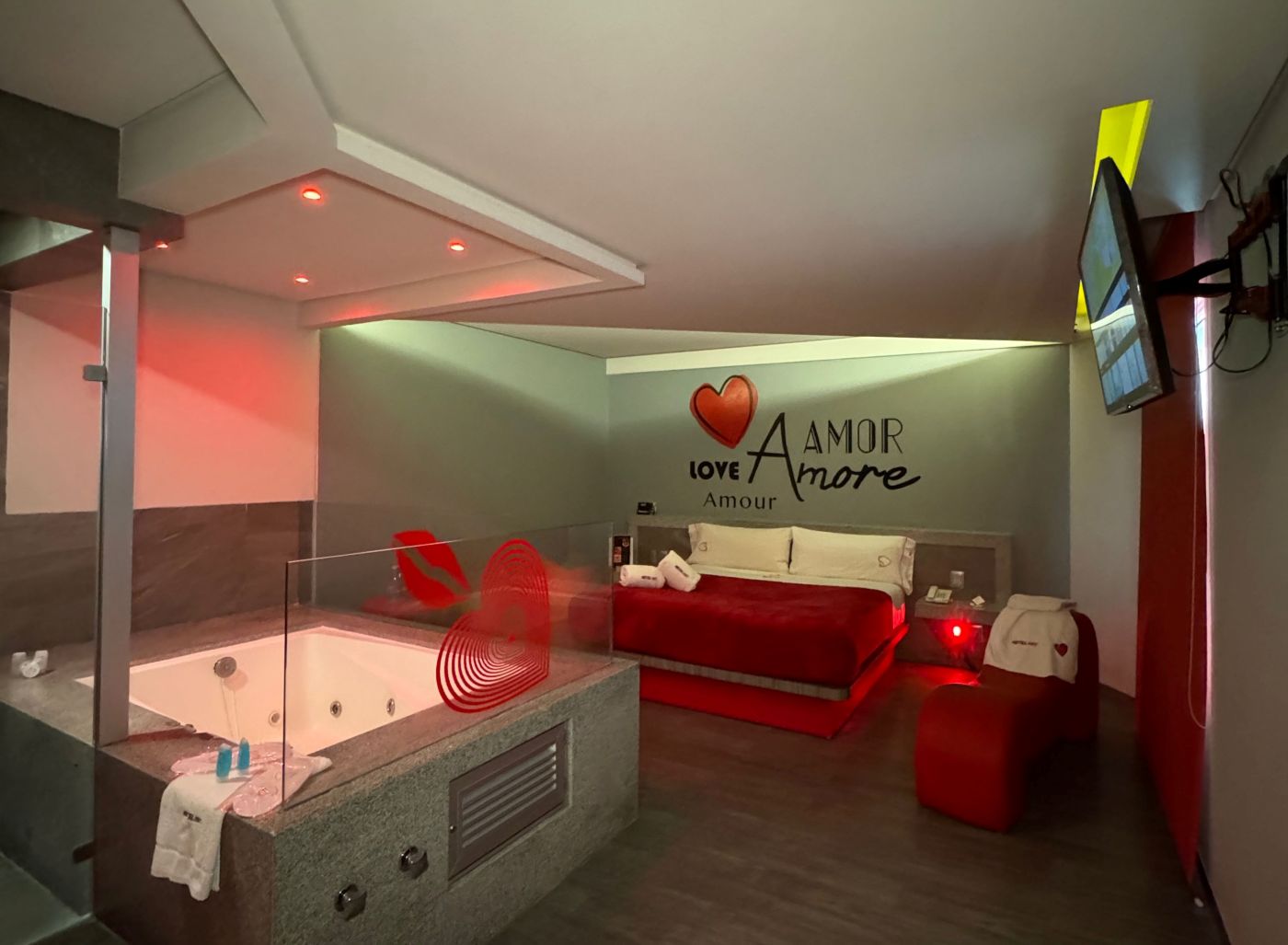 Habitación de motel con jacuzzi y motivos rojos.