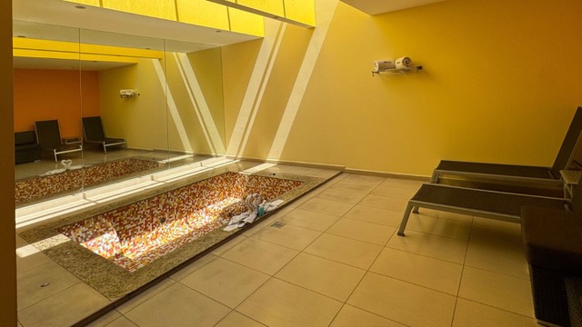 Habitación de motel con luz amarilla y un jacuzzi