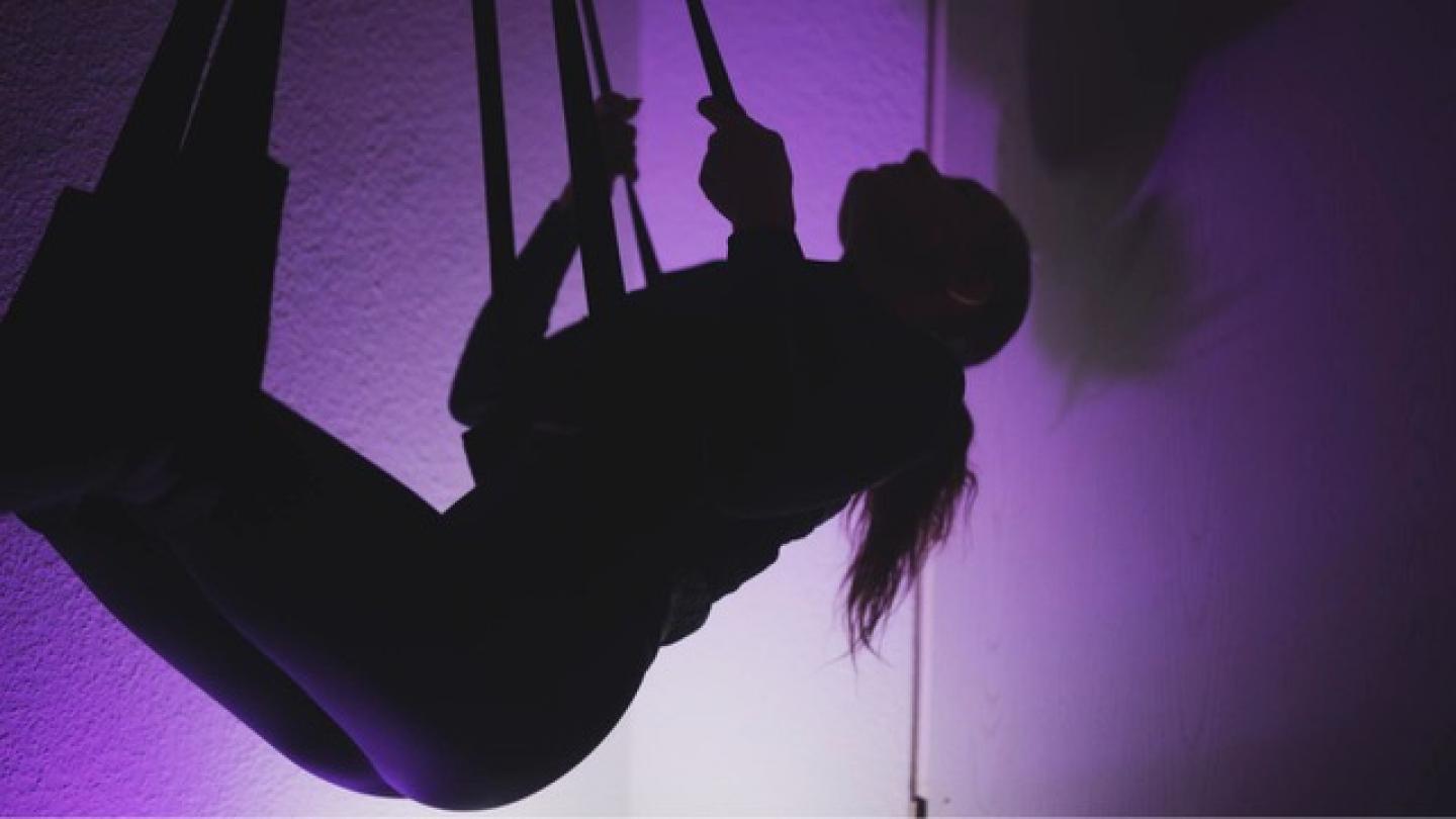  Mujer en un columpio de motel, con luz morada 