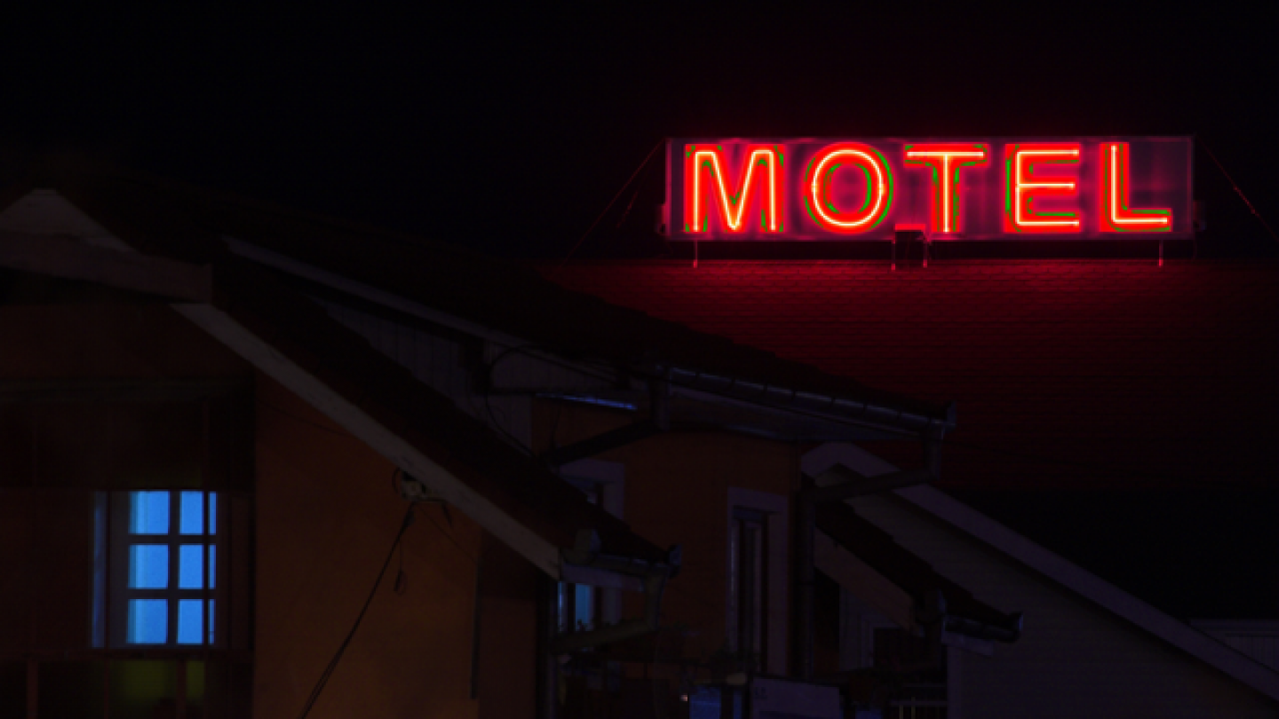 Letrero de un motel, en una noche muy oscura, con letras rojas.
